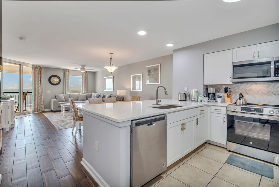 Your modern kitchen flows seamlessly into the bright living space, perfect for cooking meals while enjoying ocean views.