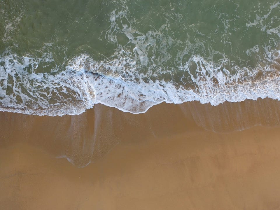 Waves caressing golden sands, nature's embrace
