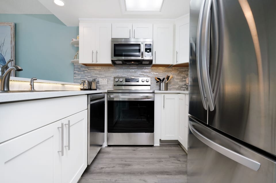 Your fully equipped kitchen features stainless steel appliances and sleek white cabinets, perfect for preparing meals during your stay.