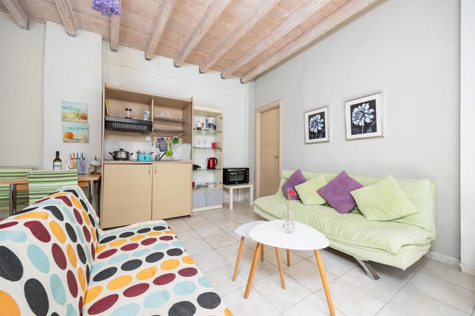 Open-plan living room with sofas, dining area, kitchen, A/C, WiFi internet, and satellite TV