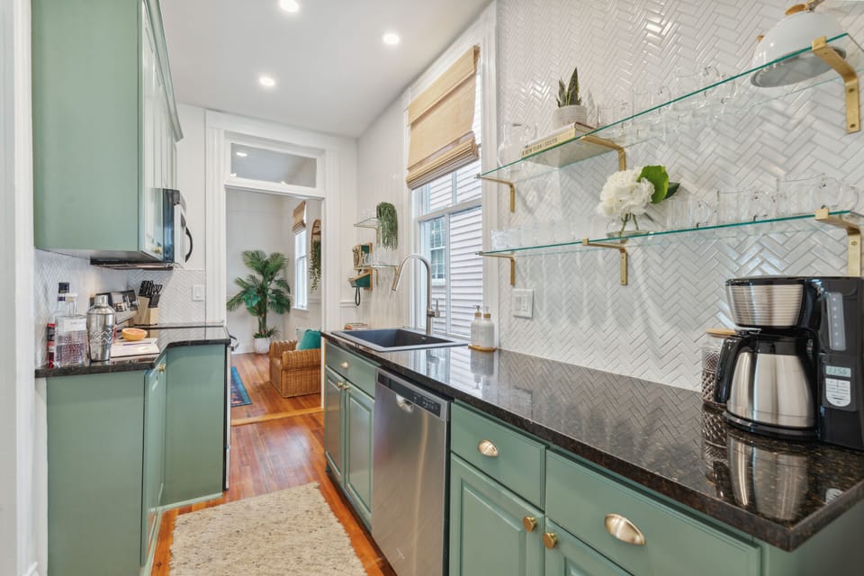 Beautifully refinished kitchen with granite countertops and green cabinets