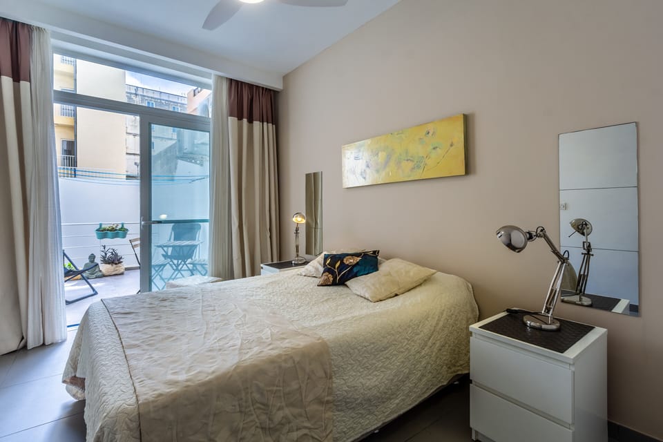 Comfortable, ealaxing bedroom leading ono a sunny back yard.