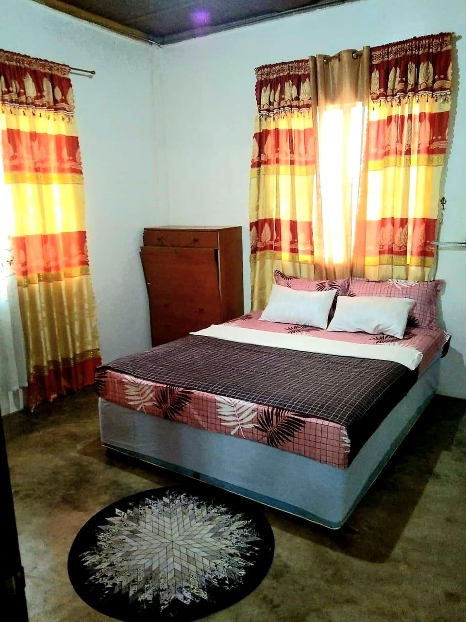 Master bedroom with vanity mirror, closet, African decor and aircon.