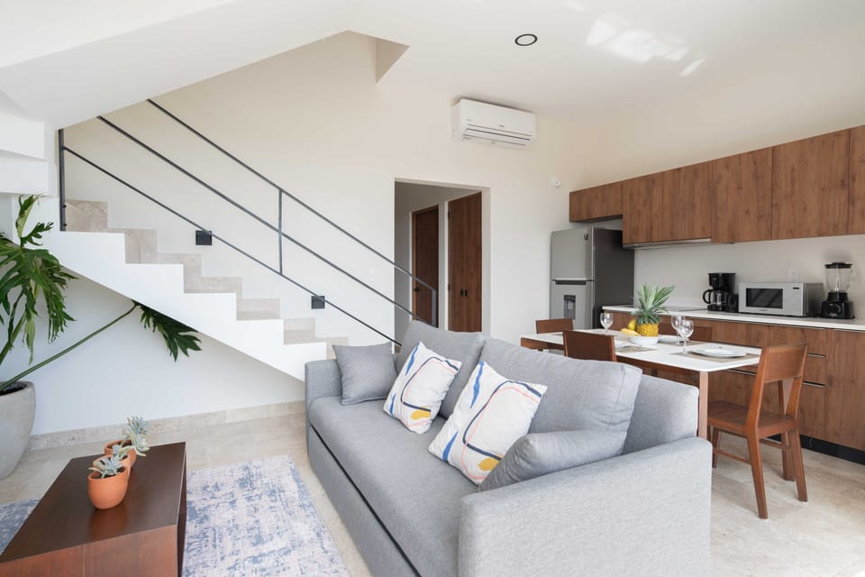 Living room, sofa bed, AC, Ceiling fan, Smart TV.