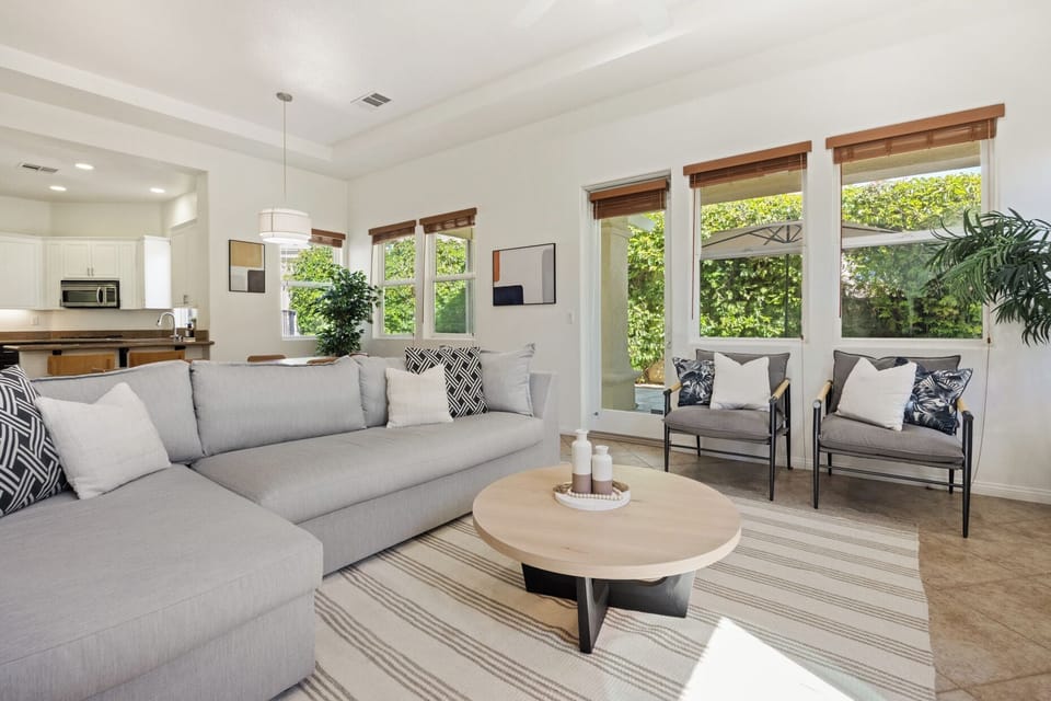 Light floods every corner—relax on soft seating with views of lush greenery outside.