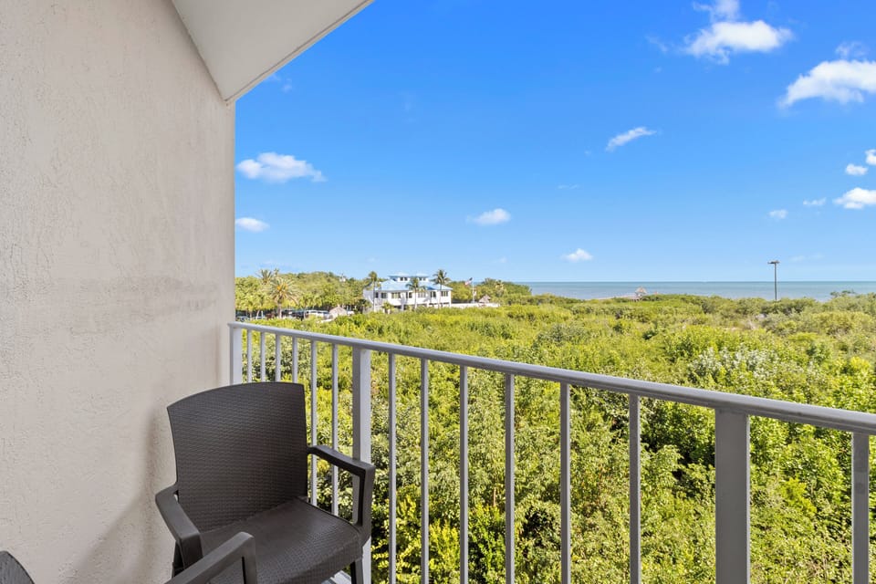 Toast the sunset from your private balcony perch above greenery.