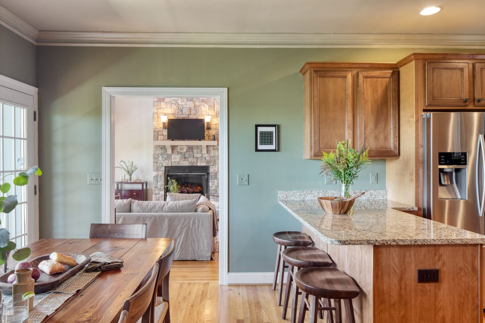Kitchen features barstool seating and modern appliances.