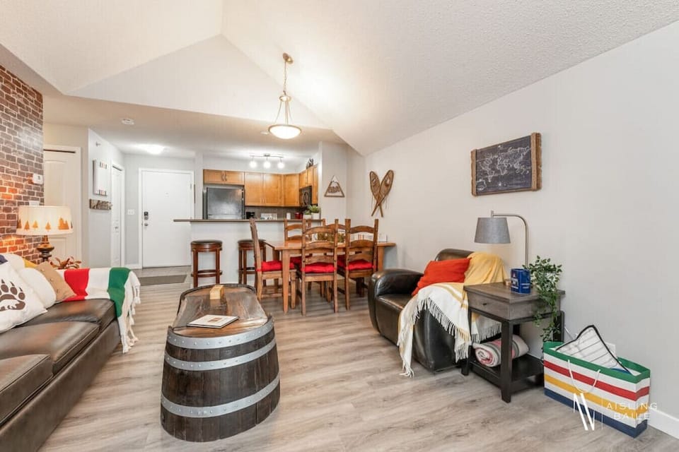 Living room with a smart TV, electric fireplace, cozy seating options and walkout access to the private, top-floor balcony.