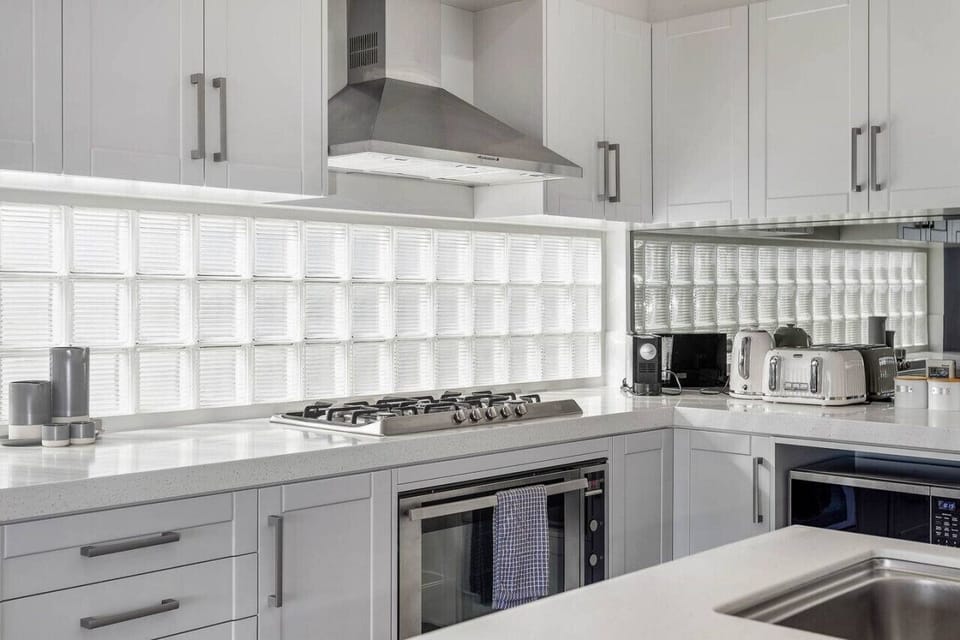 The area is equipped with a compact fridge for storing essentials, ample cupboard space for utensils and dishes, a trash can for waste disposal, and a sink for washing dishes. This functional setup allows guests to comfortably prepare and enjoy their meal