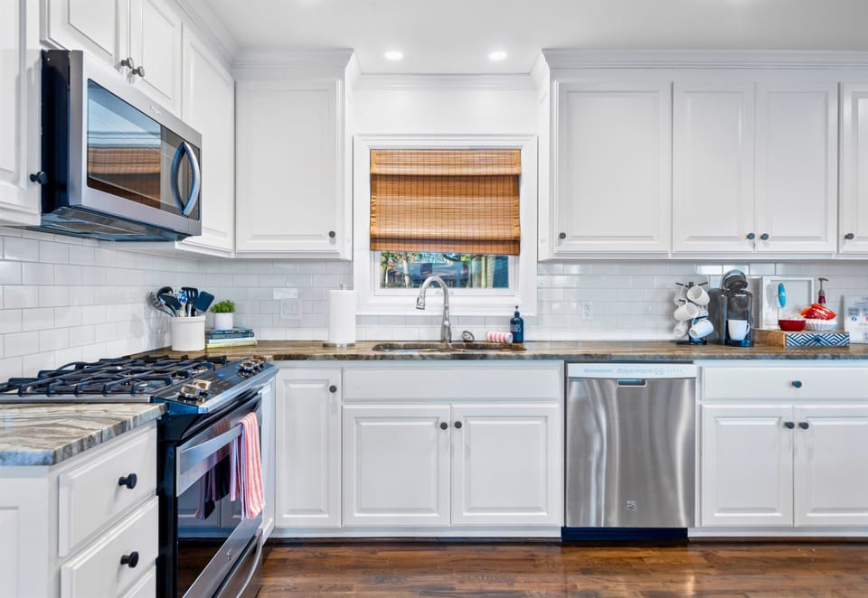 With crisp white cabinetry and sleek stainless steel appliances, this kitchen blends classic charm with modern convenience.