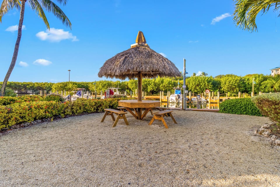 Gather for relaxed meals under a shaded tiki table.