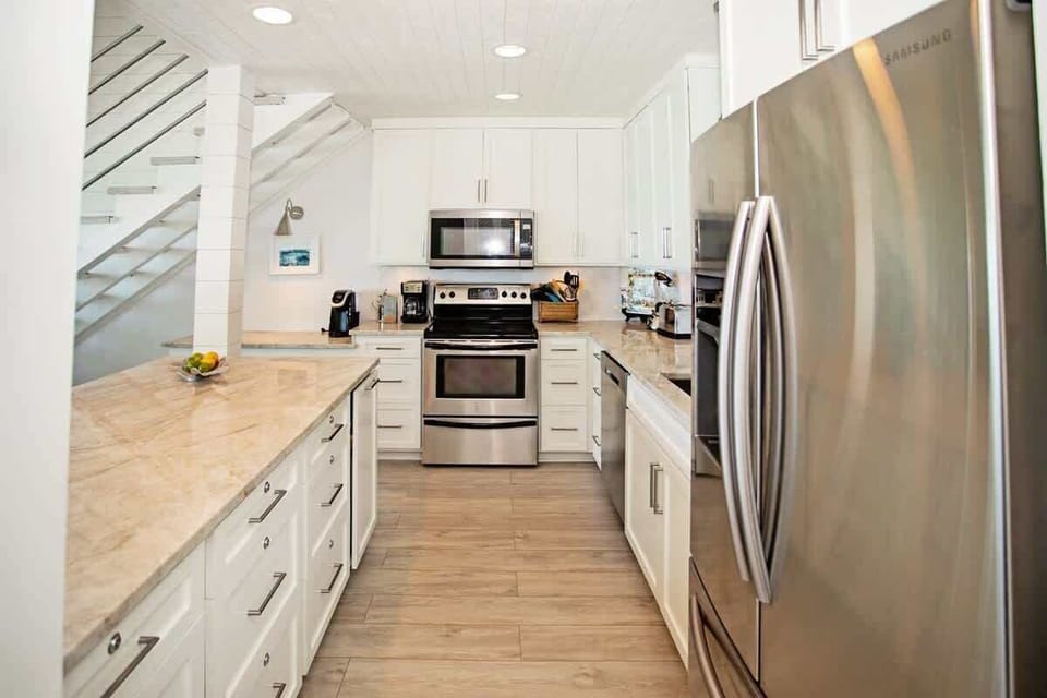 - Cook up vacation favorites in a bright, modern kitchen with stainless steel finishes - Granite countertops and modern lighting offer style and function - Fully stocked and open to the dining area, perfect for effortless entertaining