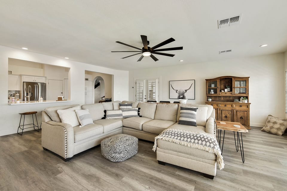 There is a sofa table behind the couch that offers more seating.