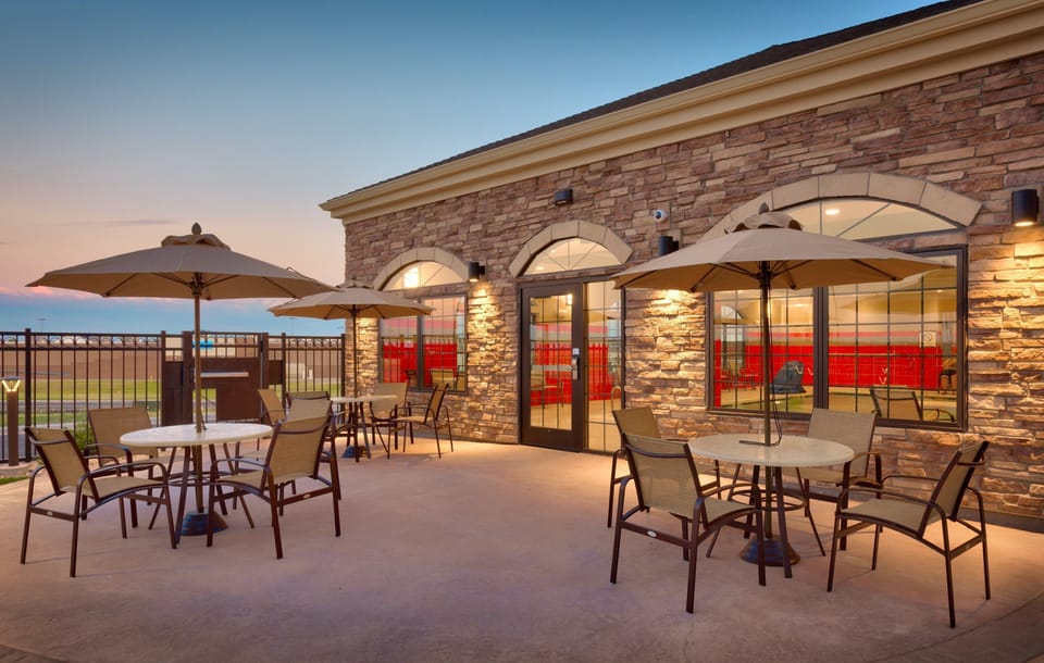 Outdoor patio seating area with tables and umbrellas.