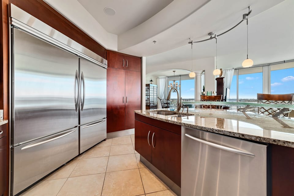 Gourmet kitchen with stainless steel appliances, granite countertops, and island seating. Open floor plan seamlessly connects to the living and dining areas.