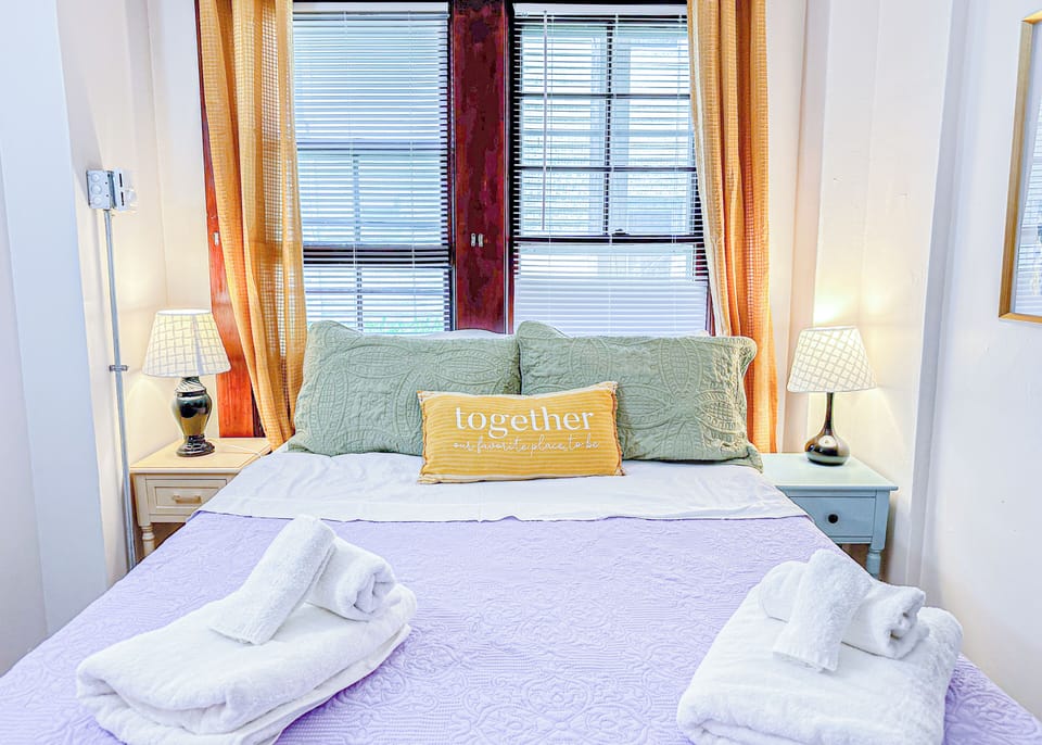 Relax in this charming and sunlit bedroom featuring a comfortable bed.