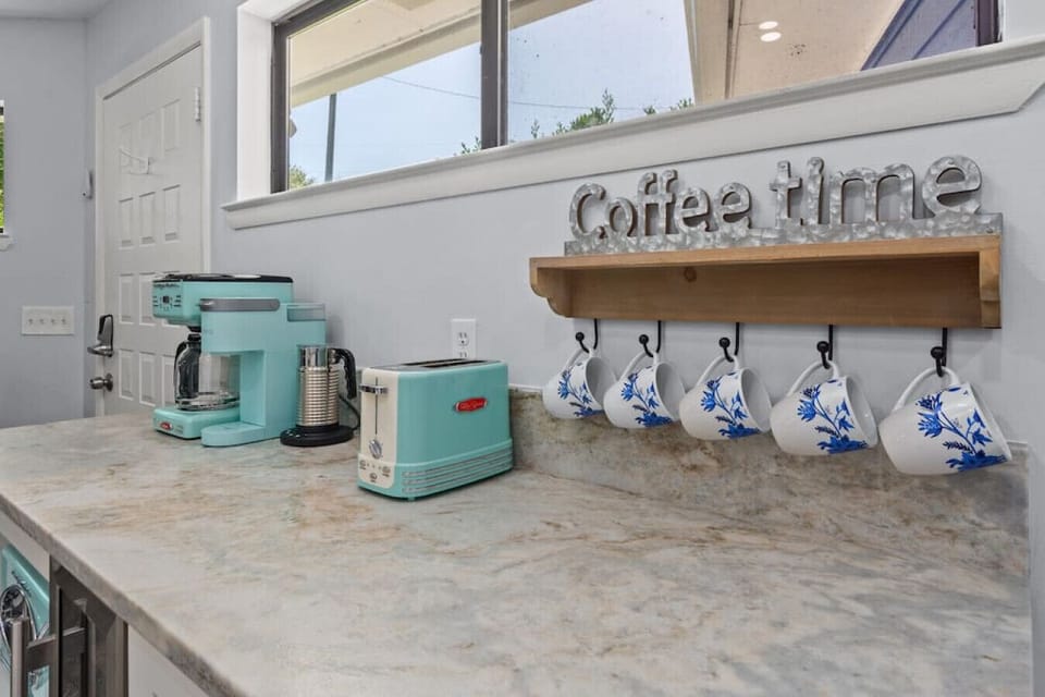 GORGEOUS fully renovated kitchen with new stainless steel appliances and high-end granite. Kitchen is fully-stocked and ready for guests to whip up a meal, make coffee at the coffee bar, and more! Featuring retro series coffee bar appliances.
