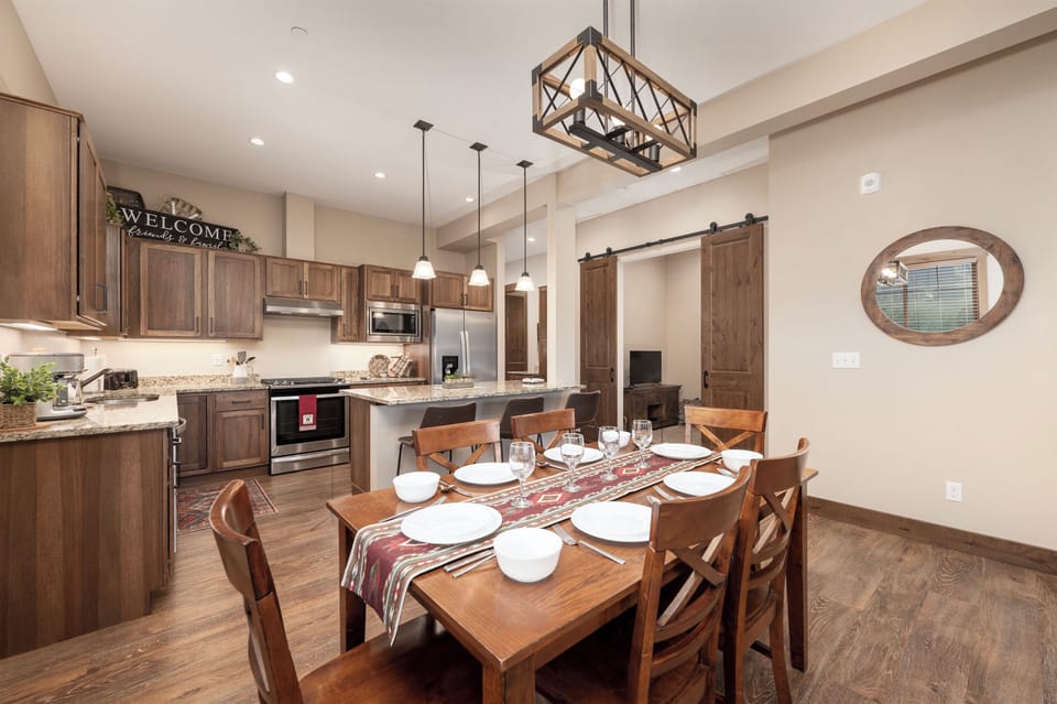 Gather around this beautifully appointed dining table where memorable meals await in your warm, rustic-modern retreat.