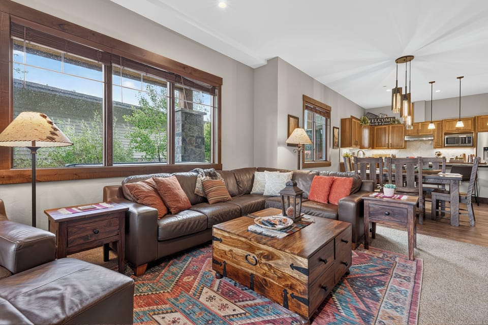 Sink into plush leather sofas in your bright, open living space where rustic wood accents and mountain views through generous windows create the perfect alpine retreat for your group to gather and unwind.
