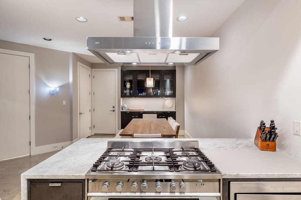 Bright open kitchen waterfall marble counters. Fisher & Paykel appliances. 
