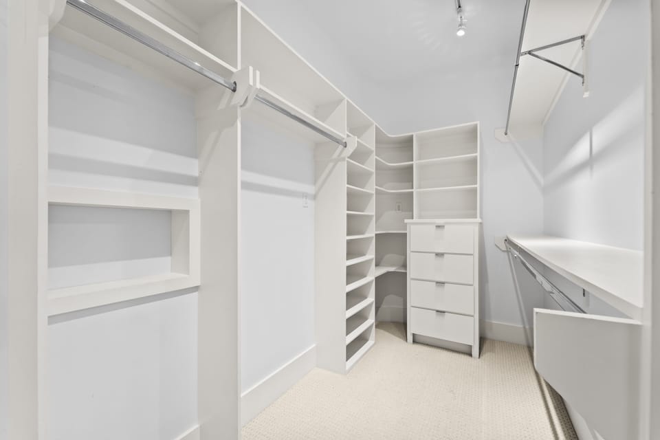 Open master closet with light bar, and 12 ft ceilings.