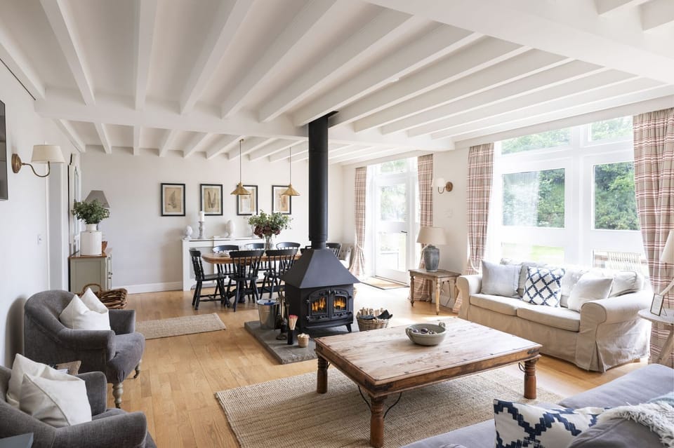 The Coach House - open plan sitting room with central wood burning stove