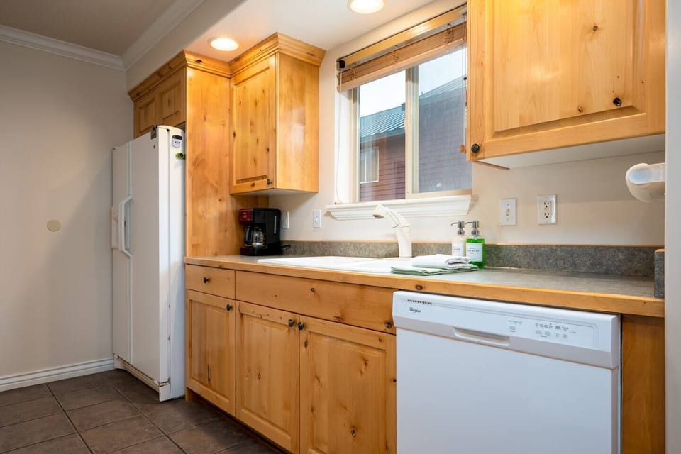 Kitchen with plenty of cabinet space, as well as a refrigerator and freezer.