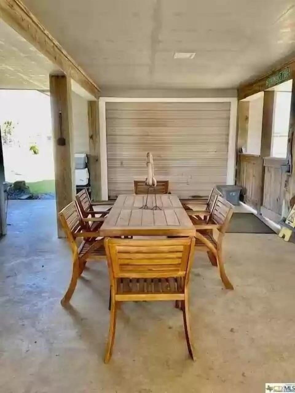 Under house patio with two 6-top tables and tons of other seating