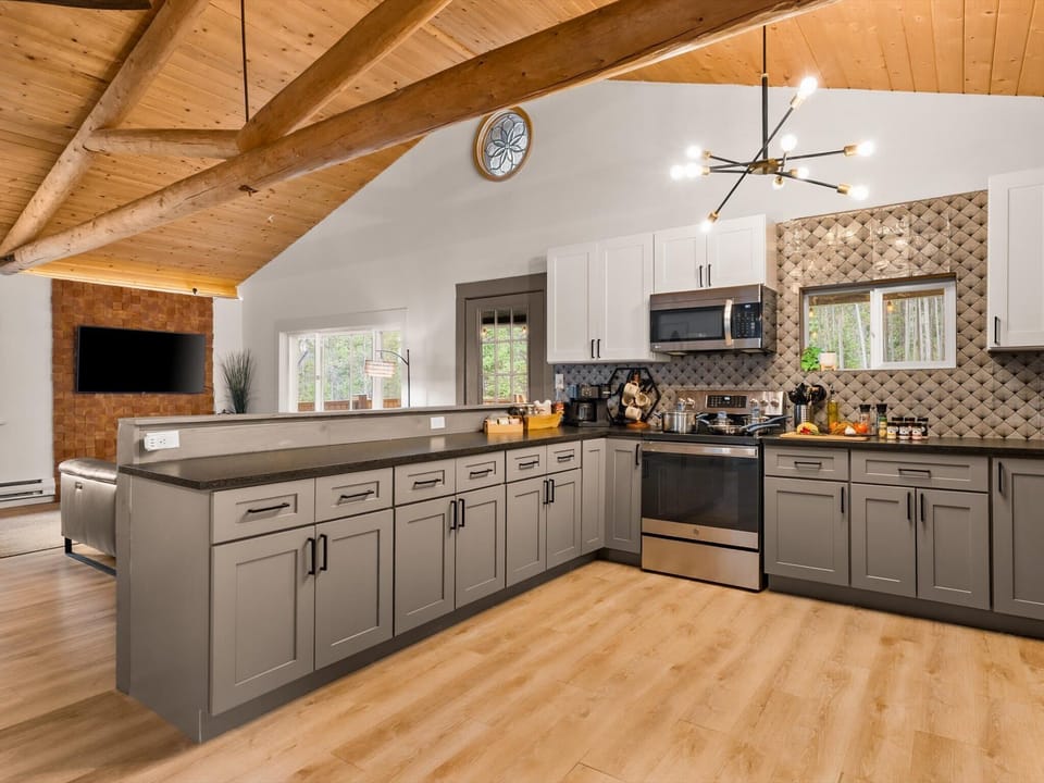 More kitchen than you expect in a mountain cabin. Vaulted pine ceilings, full appliances, and counter space for everyone who wants to help.