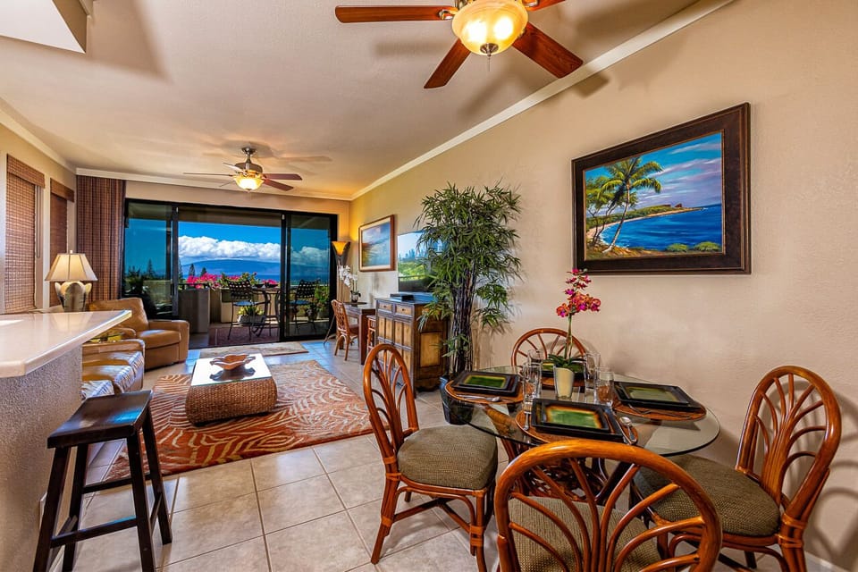 Your inviting open-concept space features tropical decor, comfortable seating, and a dining area where you can enjoy meals with stunning ocean views through expansive sliding doors.