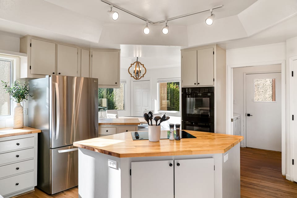 Modern, fully equipped kitchen featuring updated appliances, including a spacious refrigerator and double oven.