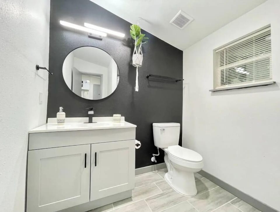 The bathroom is equipped with a mirror, towels, and cleaning products.