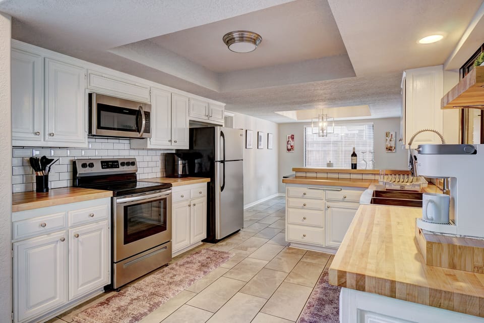 Fully equipped kitchen that includes an air fryer and coffee station.