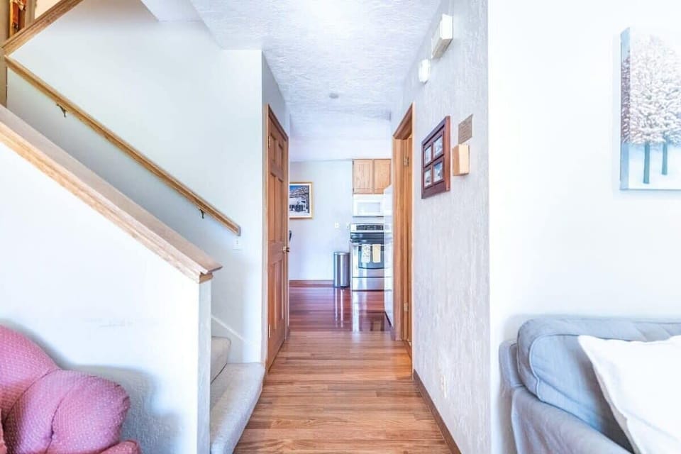 The view down the hallway from the living room looking into the dining and kitchen space.