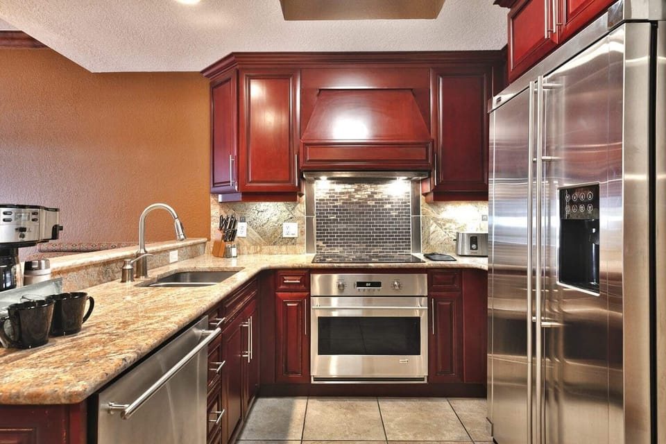 - Create meals in a chef-style kitchen with modern appliances  
- Double-door fridge and ample storage make cooking simple  
- Stylish backsplash and wood cabinets complete the space