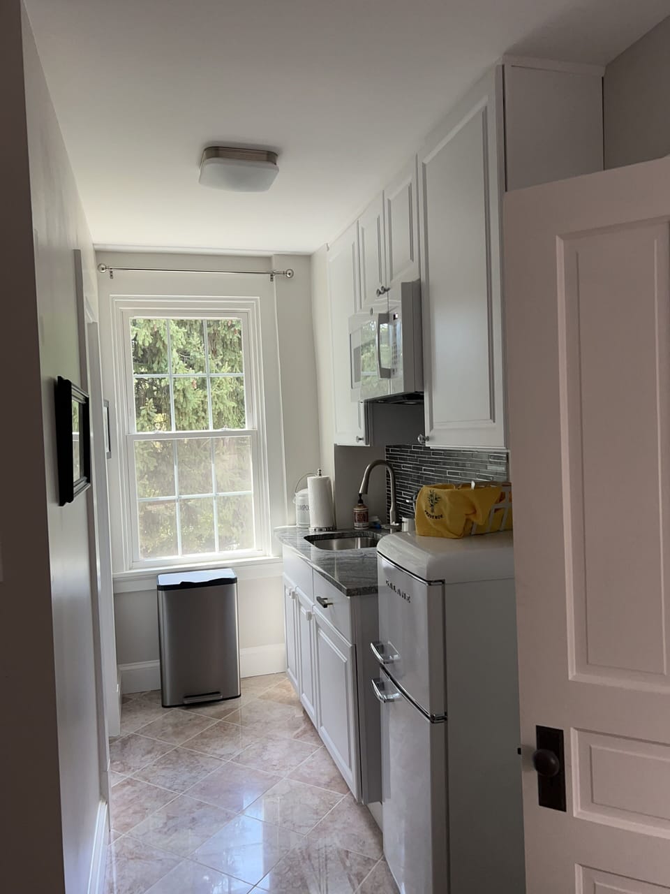 Kitchenette. Large windows throughout provide ample natural light.