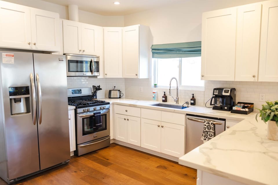Full kitchen with fridge with ice maker, gas stove, microwave, sink, dishwasher, coffee station and misc cooking items.