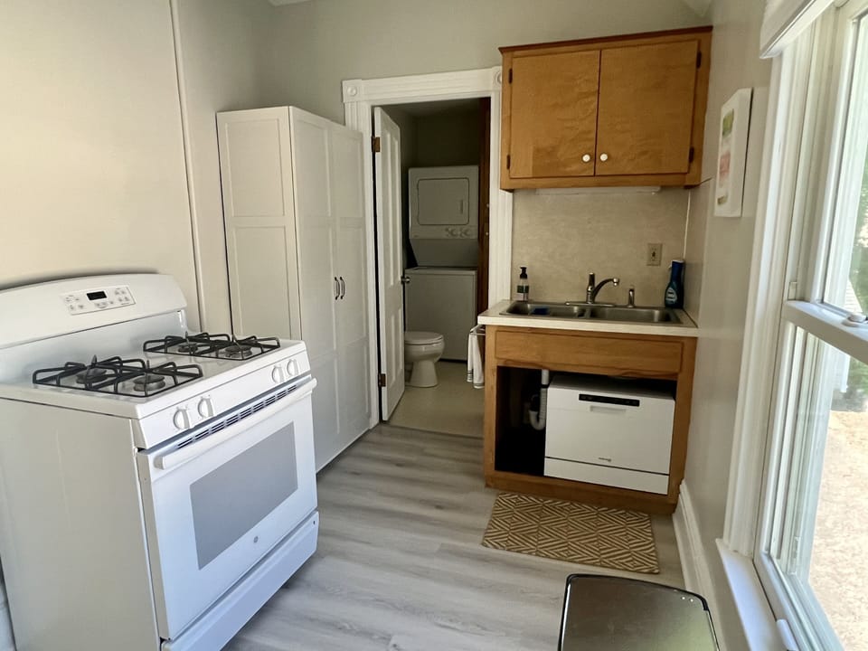 Kitchen with stove, dishwasher, pantry, refrigerator, and microwave/air fryer.