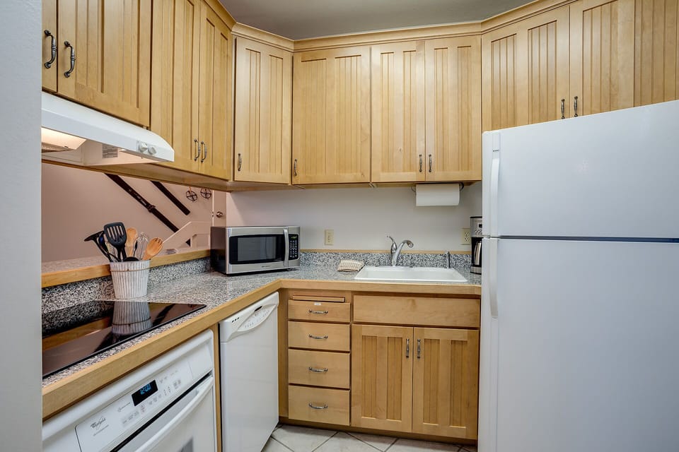 Your fully equipped kitchen features warm wood cabinetry, granite counters, and modern appliances for cooking memorable meals together.