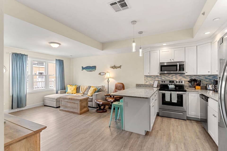First floor living room and fully stocked kitchen, with flat screen smart TV, 4 barstools, reclining chair and kitchen table.