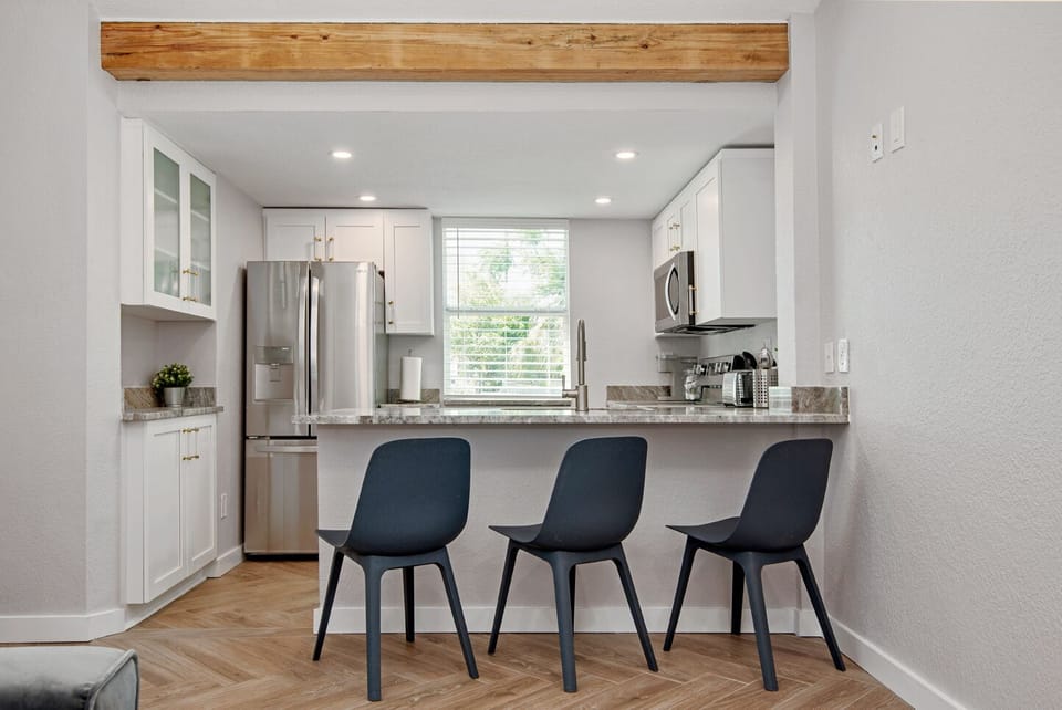Kitchen counter top with 3 chairs.