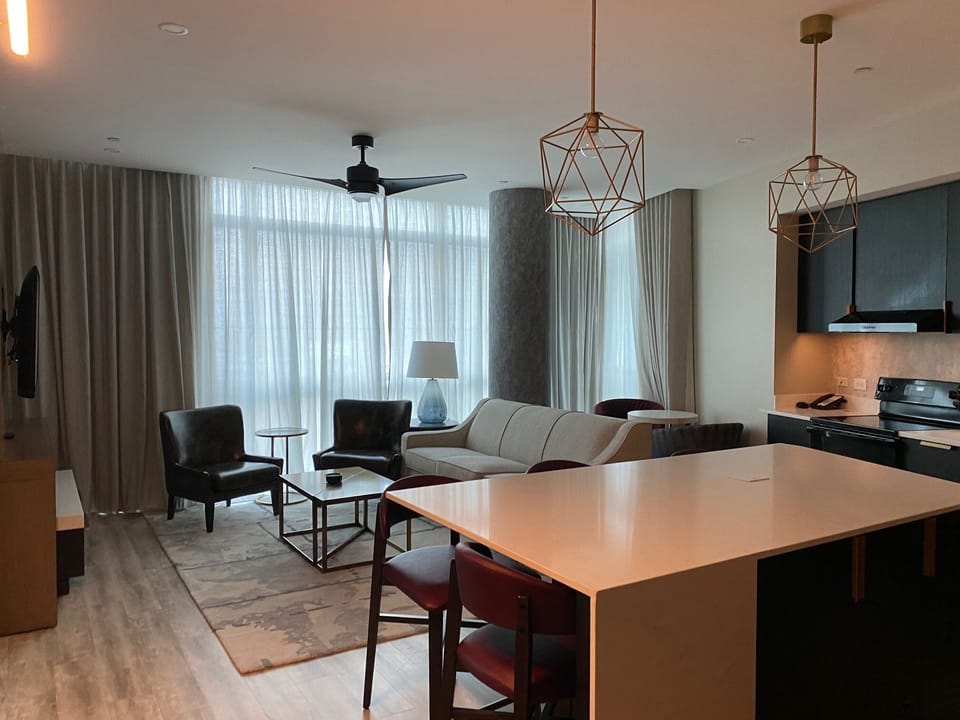 Living Room with full sofa, chairs, and TV.  Full Kitchen & counter dining for 4