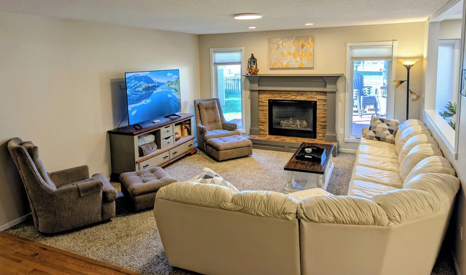 Living area on main level with 65" smart TV and gas fireplace.