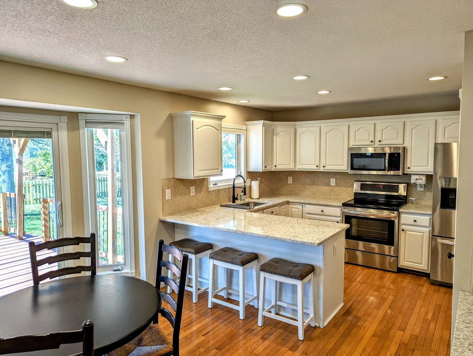 Kitchen with breakfast table and bar seating. Sliding door access to deck.