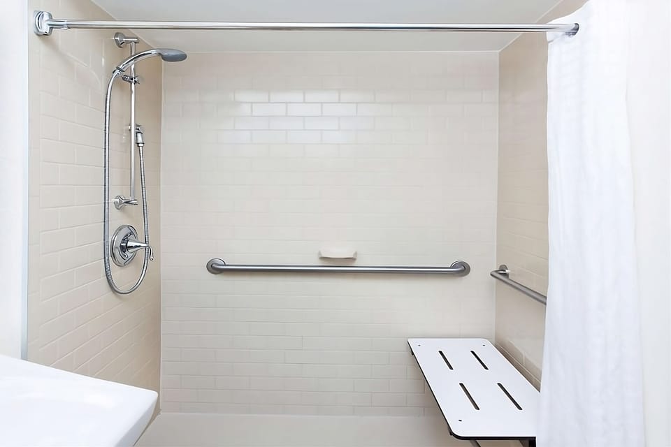 Enjoy an accessible roll-in shower with bench and grab bars.