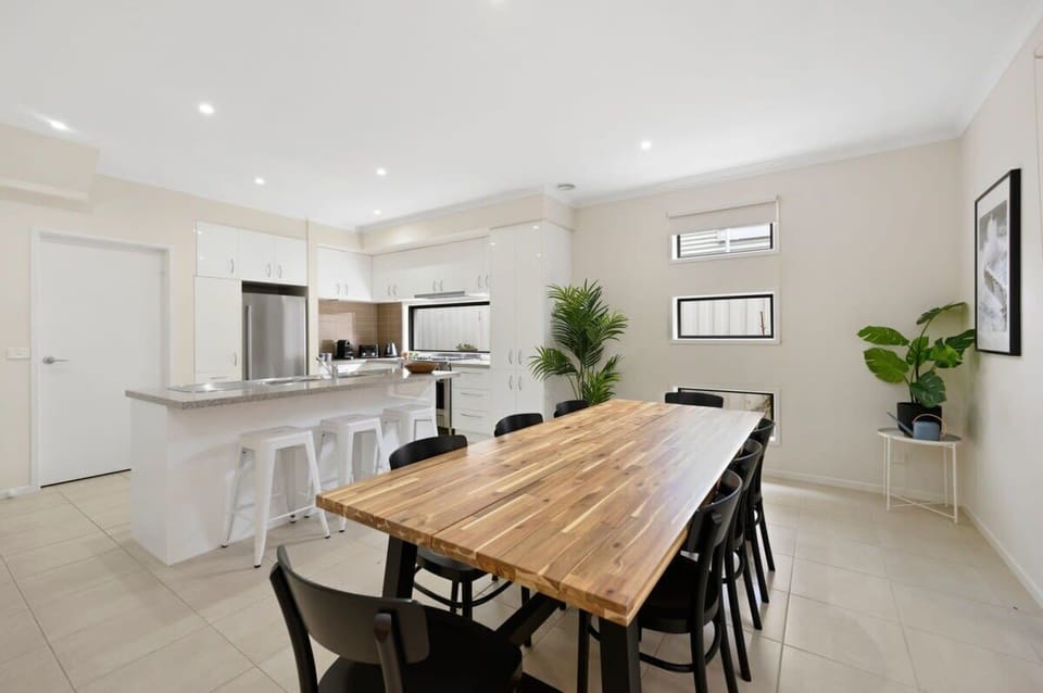 The large timber dining table comfortably seats eight, making it ideal for family meals or entertaining guests