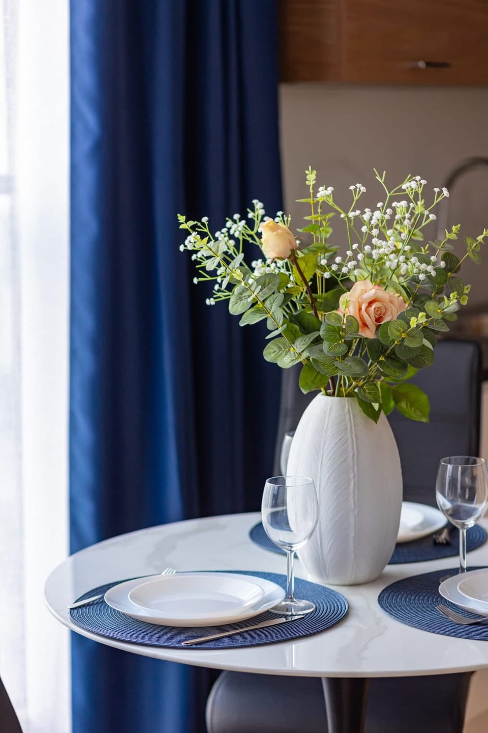A dining table set with a vase of fresh flowers and elegant tableware.
