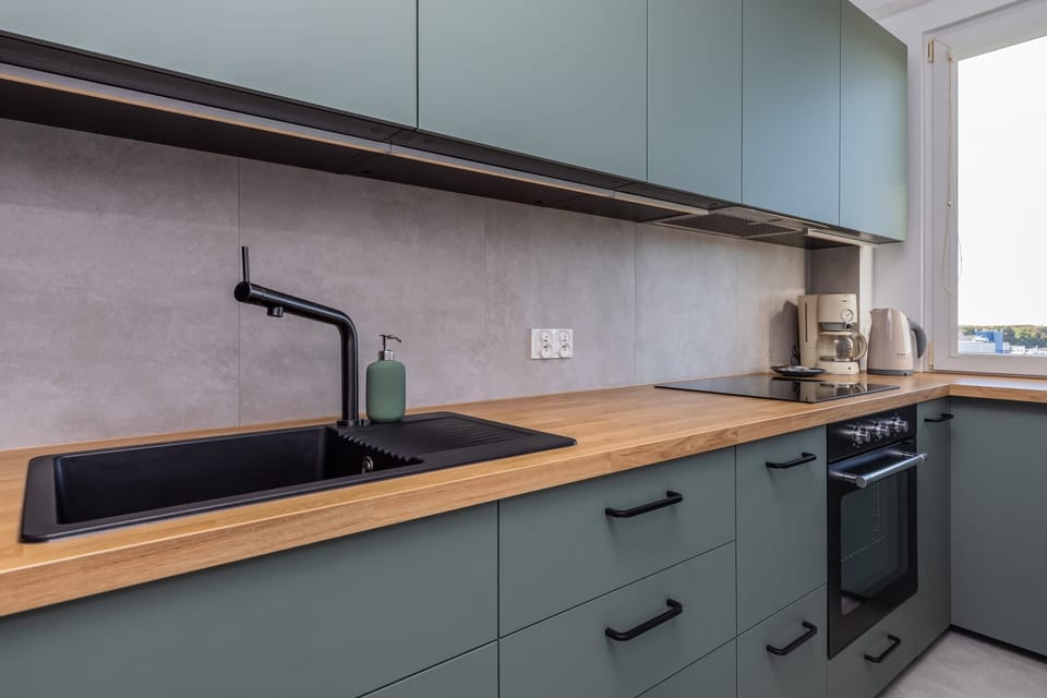 A close-up of the kitchen sink area, featuring a modern faucet and backsplash.
