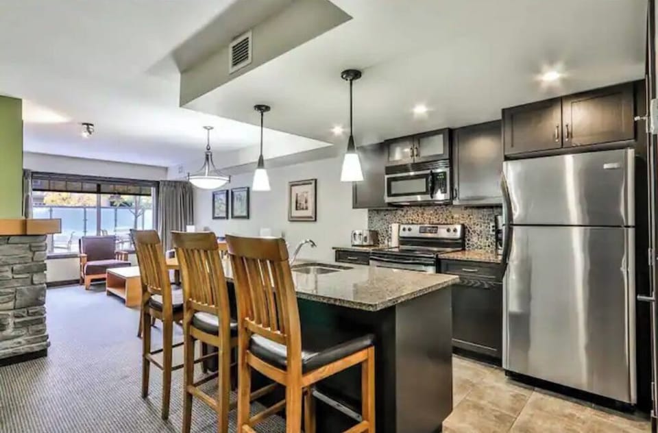 Fully-stocked kitchen with island, microwave, oven, fridge/freezer & dishwasher.