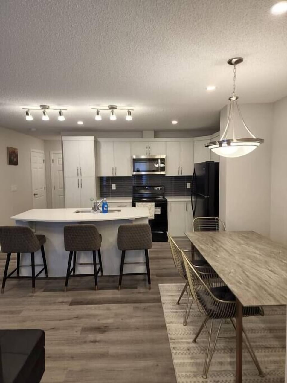 A fully furnished kitchen with chairs and a solid marble table 